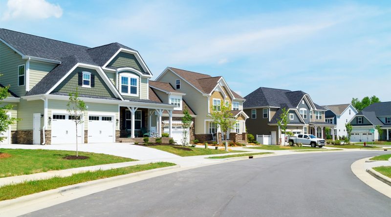 Image of a suburb in America with various different houses and a large road running through to support 15 minute cities in the us article