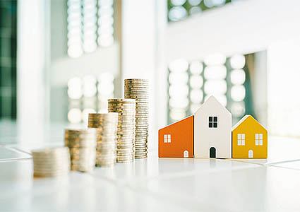 stacks of coins next to small model houses