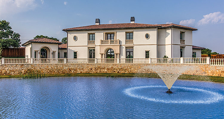 large house behind pond with fountain