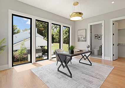 modern home office with large windows, a gray rug, and a unique desk