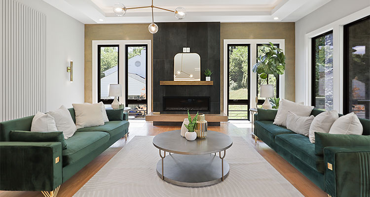 modern living room with two green velvet sofas facing each other, a central coffee table, and a fireplace