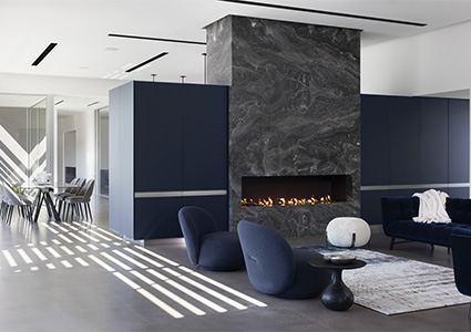 modern interior living space featuring a large, dark stone fireplace as a central element.