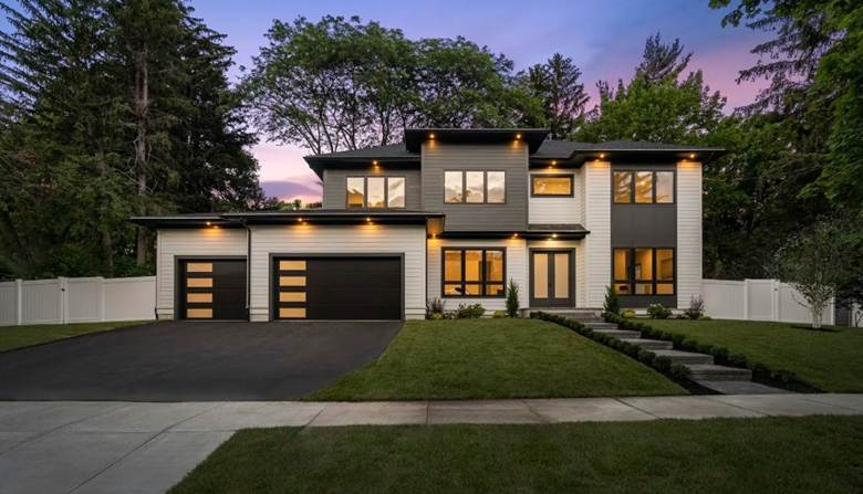 Large modern house with black garage doors to support garage door installation article