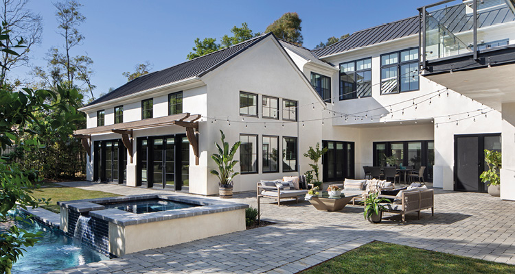 a modern two-story home featuring clean lines, light-colored brick walls, and expansive windows. 
