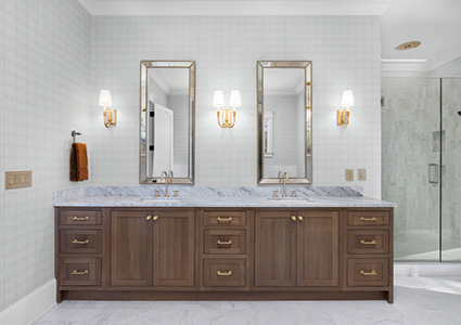 a modern double vanity with reeded wood doors and marble countertops