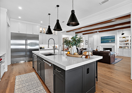 a modern, open-concept kitchen and living space characterized by a striking two-tone cabinetry design and rustic elements