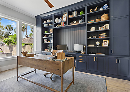  bespoke built-in home office furniture, including dark blue cabinetry and a wooden desk. 