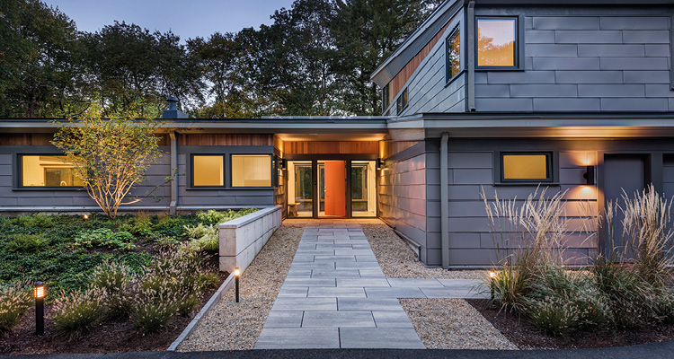 a modern, two-story residential home at dusk