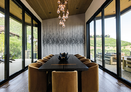 a modern dining room featuring high-end furniture, including a dark wood dining table and upholstered chairs