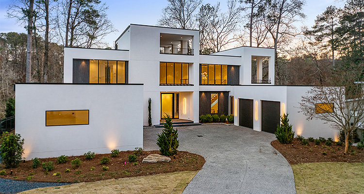 a multi-story, ultra-modern luxury mansion characterized by its stark white facade and geometric, cubic architecture