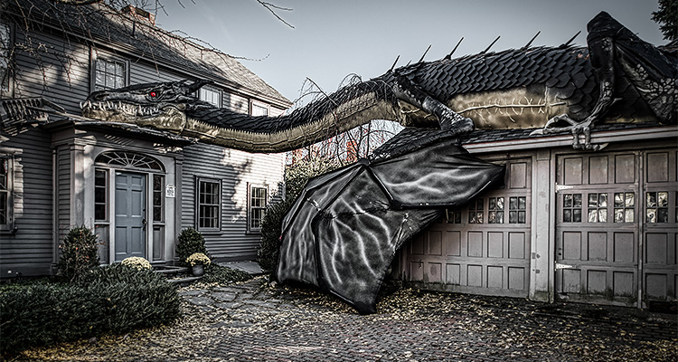 a massive, highly detailed dragon sculpture spanning across the front of a residential house and its adjacent garage