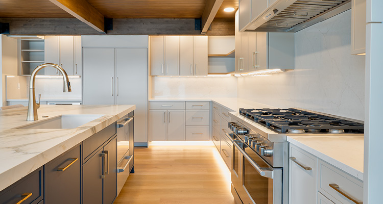 modern kitchen with a large waterfall edge quartz island and mixed-finish cabinetry
