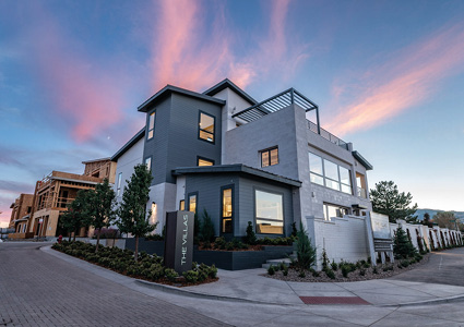 a multi-story, modern luxury villa under a vibrant dusk sky