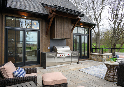 an upscale, rustic-style outdoor patio and kitchen area designed for entertaining.