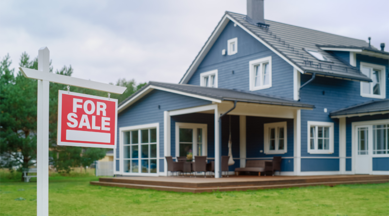 Red Home for Sale Sign in Frontyard of a Big Blue Stylish House with Traditional Architecture