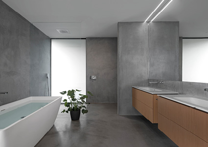 A modern bathroom features a freestanding bathtub and double vanities with wooden cabinets