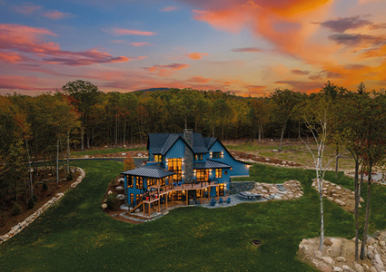 a stunning custom mountain home nestled within a peaceful, wooded landscape at sunset