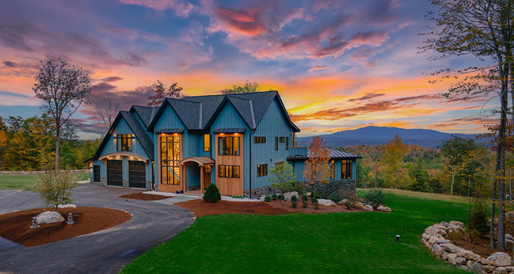 a striking contemporary home set against a dramatic mountain landscape at sunset