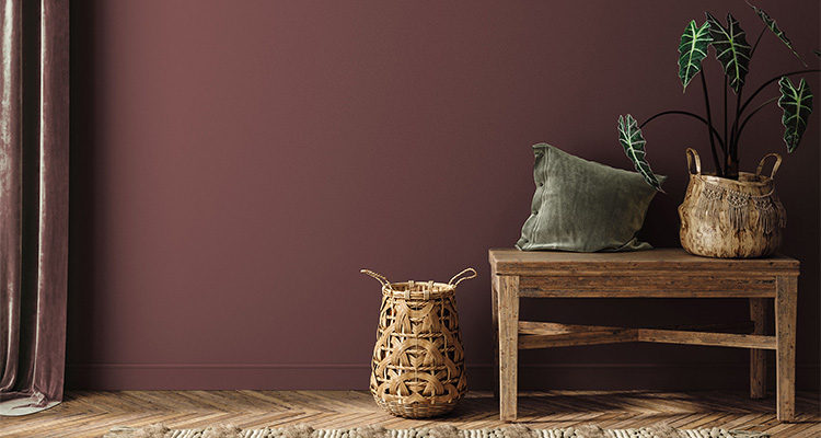 A rustic wooden bench sits against a plum-colored wall