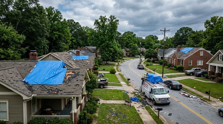 Storm damage on different roofs in street