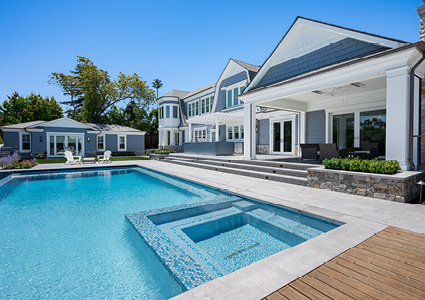 a luxurious, two-story modern estate featuring a sprawling backyard with a large swimming pool
