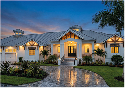 a large, luxurious one-story coastal or tropical-style house at dusk
