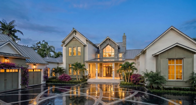 the exterior of a large, luxurious estate during twilight