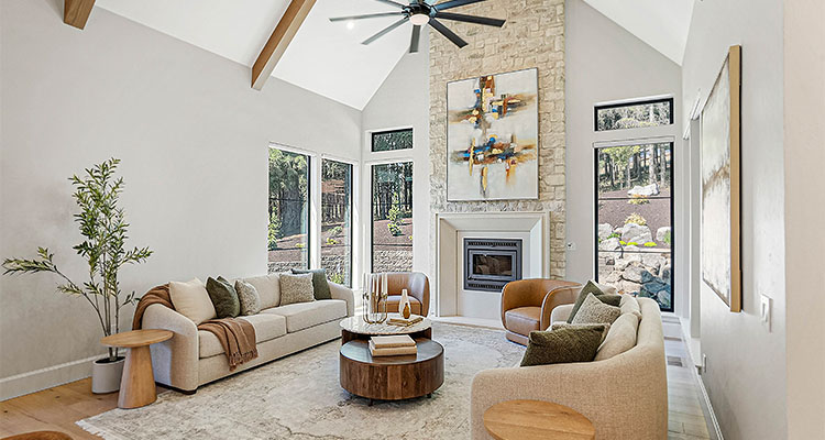 a spacious, modern living room with a high, vaulted ceiling and rustic wood beams