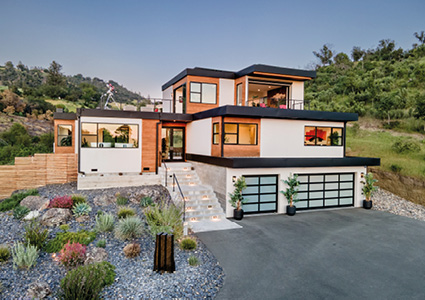 a modern, multi-level house built on a hillside.
