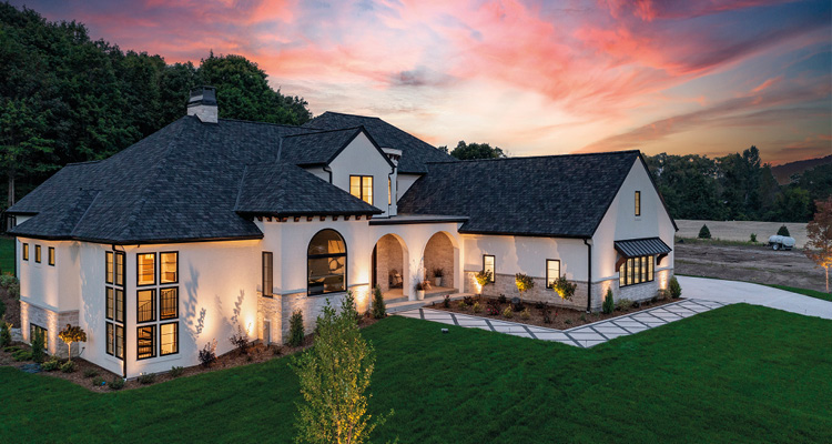 a large, modern luxury house at dusk