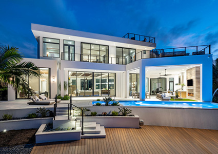 a large, modern luxury villa at twilight or night, showcasing sleek architectural lines and extensive outdoor living spaces