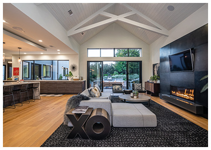 a spacious, modern, open-concept living room and kitchen with high, vaulted ceilings.