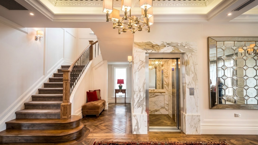 Residential elevator integration in luxury custom homes requires coordination between the elevator hoistway, interior finishes and adjacent circulation elements during the design phase to achieve seamless aesthetic integration. Image: Inclinator