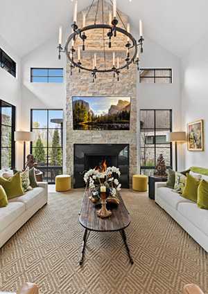 a spacious, modern living room featuring a vaulted ceiling, a floor-to-ceiling stone fireplace