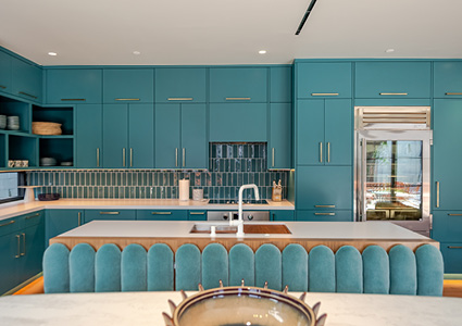 a vibrant teal kitchen with flat-panel cabinetry, a white countertop, and a fluted, channel-tufted teal island base