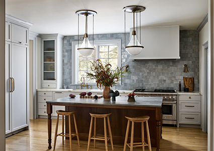 a transitional kitchen featuring a dark wood center island with a stone countertop