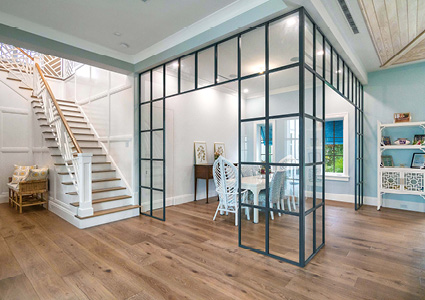 a modern industrial-style black metal and glass partition wall dividing an interior space.
