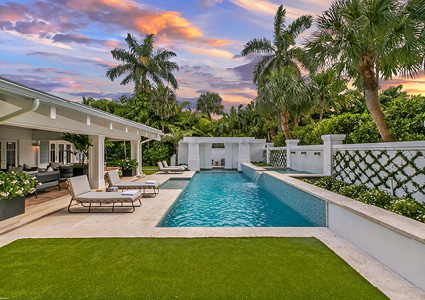 a luxury backyard pool area at sunset.