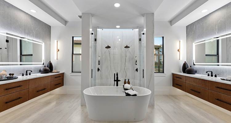 a modern, symmetrical luxury primary bathroom highlighted by dual floating wooden vanities, illuminated backlit rectangular mirrors, a central white freestanding bathtub, and a marble-tiled walk-in shower enclosure
