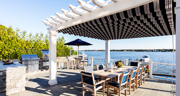 a luxurious waterfront patio designed for outdoor dining and entertainment