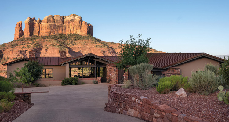 a luxurious, southwest-style ranch home positioned directly in front of the iconic Cathedral Rock formation in Sedona, Arizona